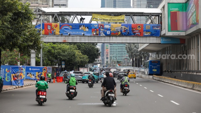 Pekerja menyelesaikan pembangunan Jembatan Penyeberangan Orang (JPO) Sarinah, Jakarta Pusat, Senin (26/1/2026). [Suara.com/Alfian Winanto]