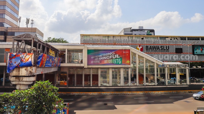Pekerja menyelesaikan pembangunan Jembatan Penyeberangan Orang (JPO) Sarinah, Jakarta Pusat, Senin (26/1/2026). [Suara.com/Alfian Winanto]