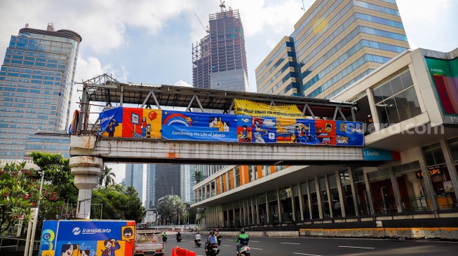 Pekerja menyelesaikan pembangunan Jembatan Penyeberangan Orang (JPO) Sarinah, Jakarta Pusat, Senin (26/1/2026). [Suara.com/Alfian Winanto]