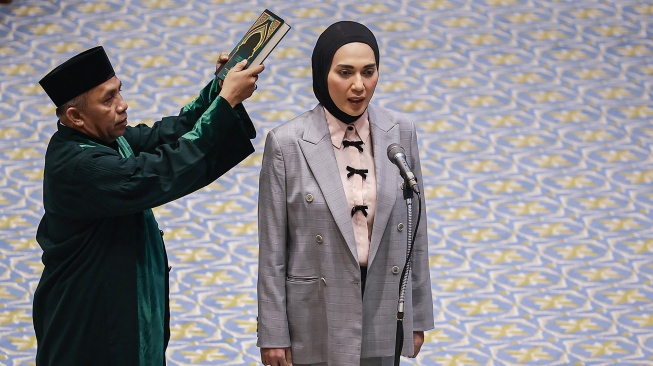 Anggota DPR Fraksi Partai Golkar Sari Yuliati (kedua kiri) mengucapkan sumpah jabatan saat dilantik pada Rapat Paripurna DPR ke-12 Masa Persidangan III Tahun Sidang 2025-2026 di Kompleks Parlemen, Senayan, Jakarta, Selasa (27/1/2026). [ANTARA FOTO/Dhemas Reviyanto/wsj]
