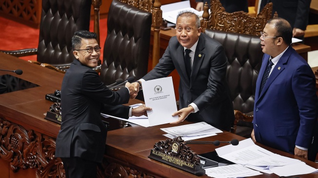 Ketua Komisi XI DPR Mukhamad Misbakhun (kiri) menyerahkan berkas laporan atas hasil uji kepatutan dan kelayakan (fit and proper test) terhadap Calon Deputi Gubernur Bank Indonesia (BI) kepada Wakil Ketua DPR Saan Mustopa (tengah) dan Cucun Ahmad Syamsurijal (kanan) pada Rapat Paripurna DPR ke-12 Masa Persidangan III Tahun Sidang 2025-2026 di Kompleks Parlemen, Senayan, Jakarta, Selasa (27/1/2026). [ANTARA FOTO/Dhemas Reviyanto/wsj]