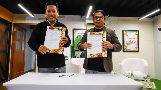 Wakil Ketua Umum AMSI Suwarjono (kiri) dan CEO Deep Intelligence Research Adi Prasetya (kanan) menekan Memorandum of Understanding kerja sama diseminasi riset di kantor Redaksi Suara.com, Jakarta, Jumat (30/1/2026). [Suara.com/Alfian Winanto]