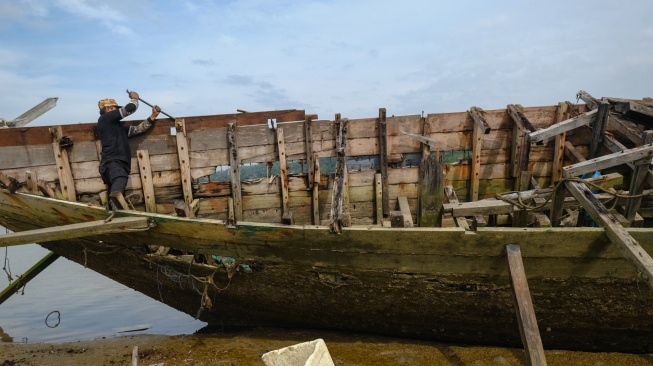 Warga membongkar bangkai kapal di kawasan Kendari Beach, Kecamatan Kendari Barat, Kendari, Sulawesi Tenggara, Selasa (3/2/2026). [ANTARA FOTO/Andry Denisah/bar]