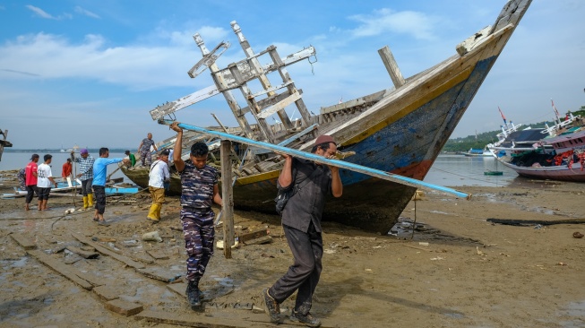 Personel TNI bersama warga bergotong royong mengangkat potongan bangkai kapal di kawasan Kendari Beach, Kecamatan Kendari Barat, Kendari, Sulawesi Tenggara, Selasa (3/2/2026). [ANTARA FOTO/Andry Denisah/bar]