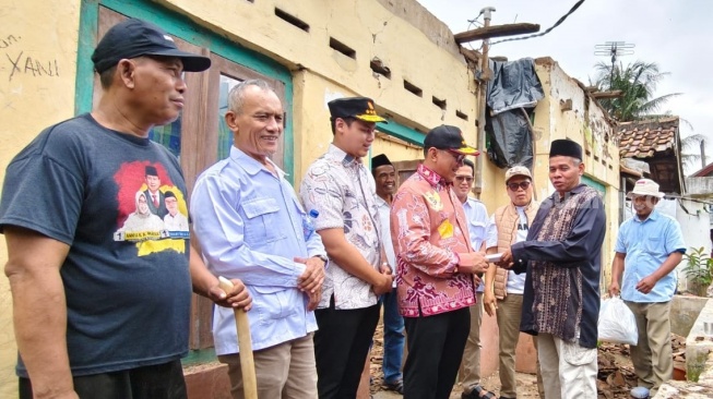 Ketua DPC Gerindra Kota Cilegon Helldy Agustian memberi bantuan bedah rumah janda bernama Saudah di Link Ciore, Kelurahan Grogol, Kota Cilegon. [Hairul Alwan/Suara.com]