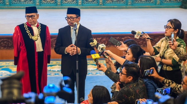 Hakim MK Adies Kadir (kiri) dan Wamenkeu Juda Agung (kedua kiri) menjawab pertanyaan wartawan usai mengikuti pembacaan sumpah jabatan pada pelantikan Hakim Mahkamah Konstitusi (MK) dan Wakil Menteri Keuangan di Istana Negara, Jakarta, Kamis (5/2/2026). [ANTARA FOTO/Galih Pradipta/foc]
