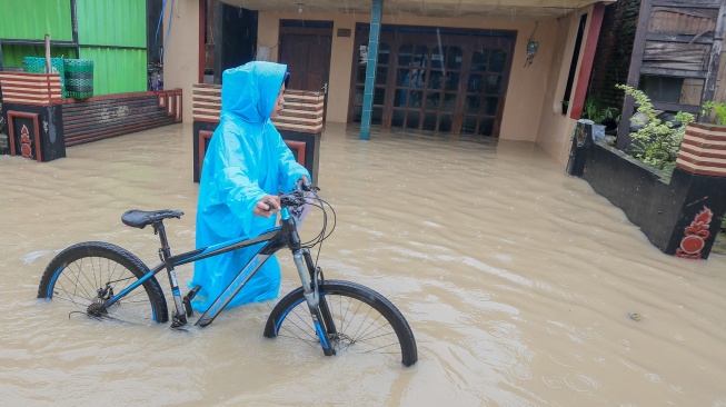 Warga mendorong sepedanya saat melintasi jalan desa yang terendam banjir di Desa Pladen, Kabupaten Kudus, Jawa Tengah, Kamis (5/2/2026). [ANTARA FOTO/Nirza/agr/wsj]
