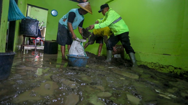 Anggota polisi bersama warga membersihkan rumah dari material lumpur usai banjir merendam Desa Pladen, Kabupaten Kudus, Jawa Tengah, Kamis (5/2/2026). [ANTARA FOTO/Nirza/agr/wsj]