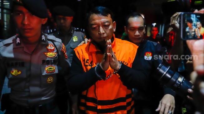 Ketua Pengadilan Negeri (PN) Depok I Wayan Eka Mariarta (tengah) dibawa ke mobil tahanan usai ditetapkan jadi tersangka di Gedung Merah Putih KPK, Jakarta, Sabtu (7/2/2026). [Suara.com/Alfian Winanto]