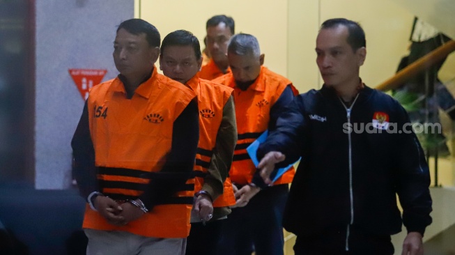 Ketua Pengadilan Negeri (PN) Depok I Wayan Eka Mariarta (kiri) dan Wakil Ketua PN Depok Bambang Setyawan (kedua kiri) dan tersangka lainnya dibawa ke mobil tahanan usai ditetapkan jadi tersangka di Gedung Merah Putih KPK, Jakarta, Sabtu (7/2/2026). [Suara.com/Alfian Winanto]