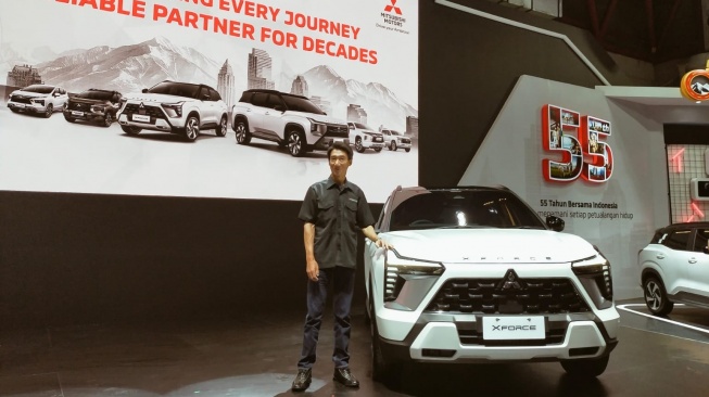 Masaaki Fujiwara, Executive Vice President PT MMKSI bersama Mitsubishi Xforce edisi 55th Anniversary Edition di IIMS 2026 (Suara.com/CNR ukirsari)
