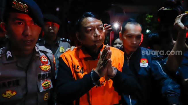 Ketua Pengadilan Negeri (PN) Depok I Wayan Eka Mariarta (tengah) dibawa ke mobil tahanan usai ditetapkan jadi tersangka di Gedung Merah Putih KPK, Jakarta, Sabtu (7/2/2026). [Suara.com/Alfian Winanto]