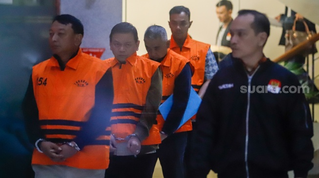 Ketua Pengadilan Negeri (PN) Depok I Wayan Eka Mariarta (kiri) dan Wakil Ketua PN Depok Bambang Setyawan (kedua kiri) dan tersangka lainnya dibawa ke mobil tahanan usai ditetapkan jadi tersangka di Gedung Merah Putih KPK, Jakarta, Sabtu (7/2/2026). [Suara.com/Alfian Winanto]