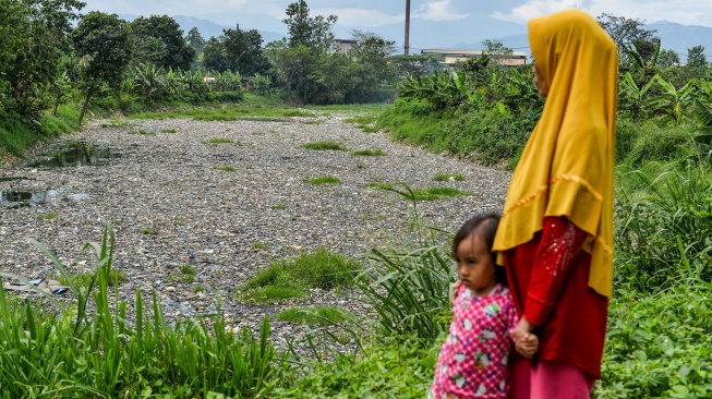 Warga mengamati sampah yang menumpuk di Sungai Citarum Lama, di Margaasih, Kabupaten Bandung, Jawa Barat, Kamis (12/2/2026). 
[ANTARA FOTO/Raisan Al Farisi/bar]
