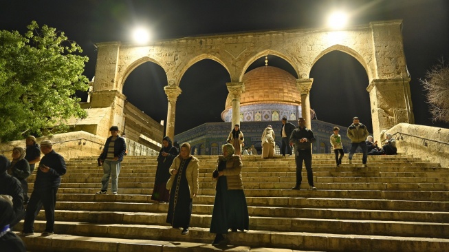 Umat Islam berjalan dengan latar belakang Masjid Dome of the Rock di Komplek Al-Aqsa, kawasan Kota Tua Yerussalem, Kamis (12/2/2026). [ANTARA FOTO/Muhammad Adimaja/wsj]