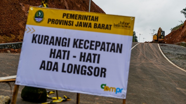Pekerja mengoperasikan alat berat saat perbaikan jalan yang longsor di Jalur Lingkar Utara Jatigede, Kabupaten Sumedang, Jawa Barat, Jumat (13/2/2026). [ANTARA FOTO/Raisan Al Farisi/nz]