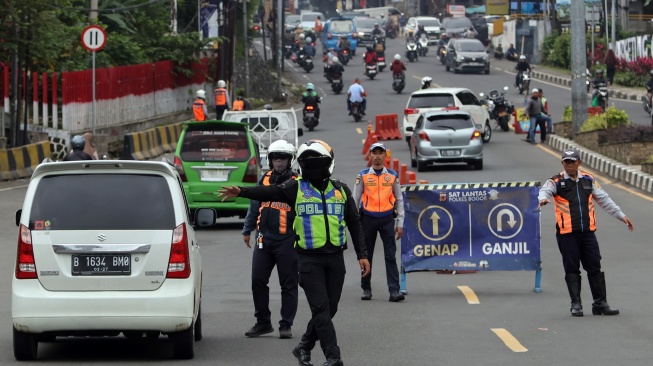 Petugas Satlantas Polres Bogor dan petugas Dishub Kabupaten Bogor mengarahkan kendaraan wisatawan saat penyekatan kendaraan nomor polisi ganjil genap di jalur wisata Puncak, Gadog, Kabupaten Bogor, Jawa Barat, Senin (16/2/2026). [ANTARA FOTO/Yulius Satria Wijaya/nz]