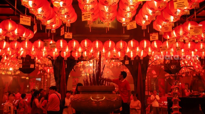 Umat Konghucu beribadah malam perayaan Tahun Baru Imlek 2577 Kongzili di Wihara Boen San Bio, Kota Tangerang, Banten, Senin (16/2/2026).  [Suara.com/Alfian Winanto]