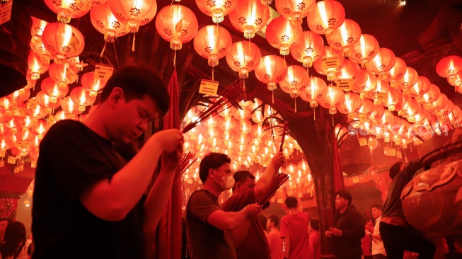 Umat Konghucu beribadah malam perayaan Tahun Baru Imlek 2577 Kongzili di Wihara Boen San Bio, Kota Tangerang, Banten, Senin (16/2/2026).  [Suara.com/Alfian Winanto]