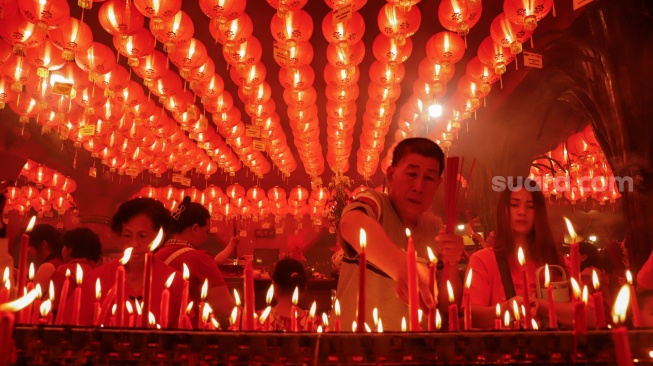 Umat Konghucu beribadah malam perayaan Tahun Baru Imlek 2577 Kongzili di Wihara Boen San Bio, Kota Tangerang, Banten, Senin (16/2/2026).  [Suara.com/Alfian Winanto]