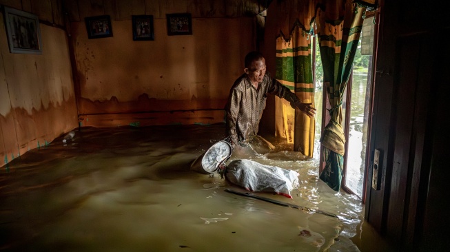 Seorang warga Mustakim (55) memeriksa kondisi rumahnya yang tegenang banjir di Desa Pilangwetan, Kecamatan Kebonagung,Kabupaten Demak, Jawa Tengah, Selasa (17/2/2026). [ANTARA FOTO/Aji Styawan/bar]