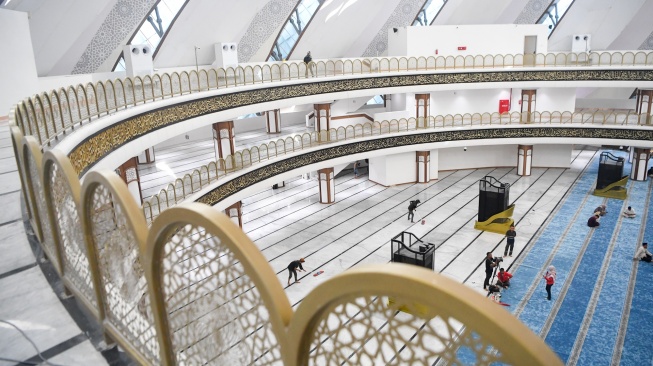 Petugas membersihkan lantai di dalam Masjid Negara Ibu Kota Nusantara (IKN) di Penajam Paser Utara, Kalimantan Timur, Selasa (17/2/2026). [ANTARA FOTO/M Risyal Hidayat/foc]