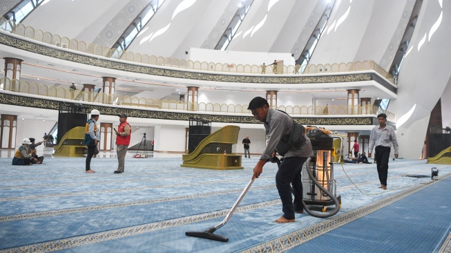 Petugas membersihkan karpet di dalam Masjid Negara Ibu Kota Nusantara (IKN) di Penajam Paser Utara, Kalimantan Timur, Selasa (17/2/2026). [ANTARA FOTO/M Risyal Hidayat/foc]
