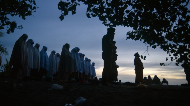 Jamaah Tarekat Syattariyah melaksanakan shalat magrib saat mengikuti tradisi maniliak bulan (hilal), di Pantai Ulakan, Padangpariaman, Sumatera Barat, Kamis (19/2/2026). [ANTARA FOTO/Fitra Yogi/foc]