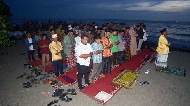 Jamaah Tarekat Syattariyah melaksanakan shalat magrib saat mengikuti tradisi maniliak bulan (hilal), di Pantai Ulakan, Padangpariaman, Sumatera Barat, Kamis (19/2/2026). [ANTARA FOTO/Fitra Yogi/foc]