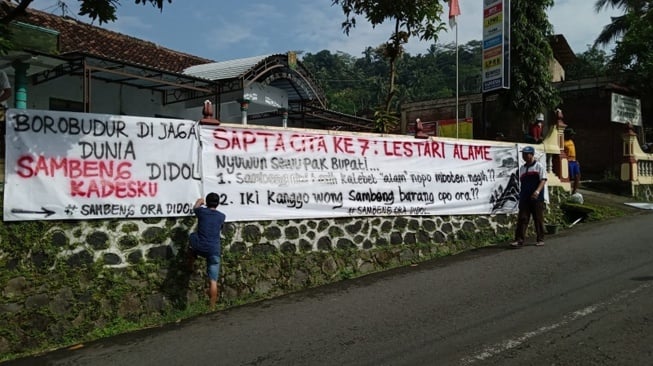  Spanduk menolak penambangan tanah urug terpasang di depan Kantor Desa Sambeng, Borobudur. (Suara.com/ Angga Haksoro A)