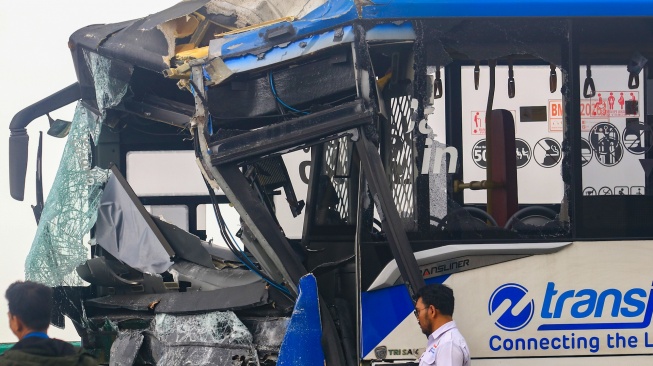 Petugas berada di dekat bus TransJakarta yang mengalami kecelakaan tabrakan antar sesama bus TransJakarta di jalur layang atau jalur langit Koridor 13, Cipulir, Jakarta, Senin (23/2/2026). [ANTARA FOTO/Muhammad Iqbal/YU]