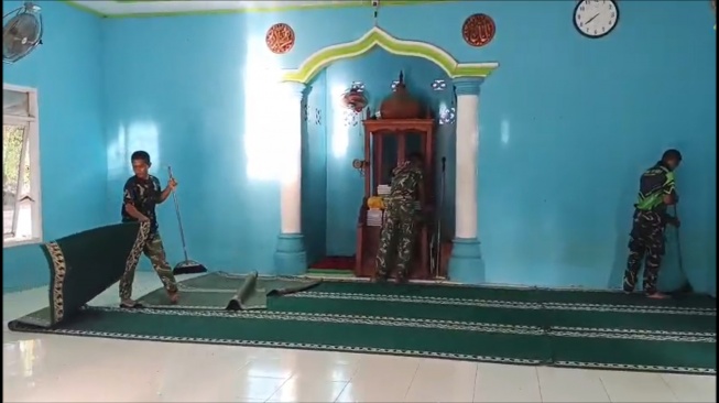 Personel TNI bersama masyarakat bahu-membahu membersihkan tempat ibadah masjid di lokasi terdampak bencana Sumatera (Dok: Bakom 2026)