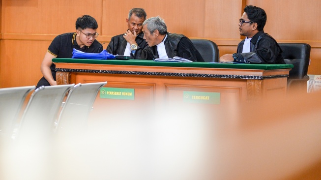 Tersangka dugaan kasus penghinaan terhadap Suku Sunda Muhammad Adimas Firdaus Putra Nasihan alias Resbob (kiri) berbincang dengan kuasa hukumnya saat menjalani sidang perdana di Pengadilan Negeri Bandung, Jawa Barat, Senin (23/2/2026). [ANTARA FOTO/Raisan Al Farisi/YU]