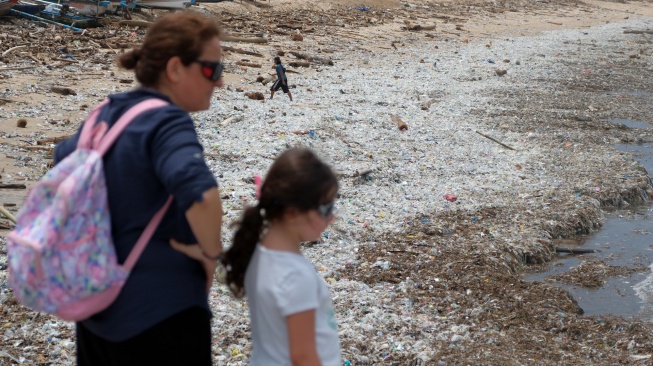 Wisatawan mancanegara melihat tumpukan sampah kiriman di Pantai Kedonganan, Badung, Bali, Kamis (26/2/2026). [ANTARA FOTO/Nyoman Hendra Wibowo/rwa]