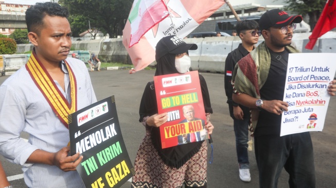 Sejumlah massa membentangkan poster saat mengikuti aksi solidaritas untuk Iran di depan Kedubes Amerika di Jakarta, Selasa (3/3/2026). [Suara.com/Alfian Winanto]