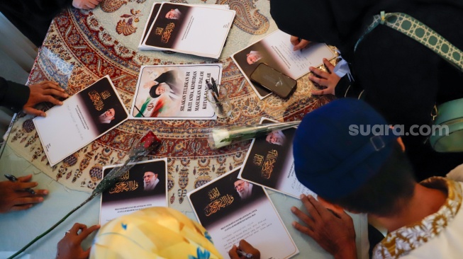 Warga menuliskan pesan dukungan saat Aksi Solidaritas dan Doa Bersama untuk Iran di Kediaman Duta Besar Iran, Jakarta, Kamis (5/3/2026). [Suara.com/Alfian Winanto]