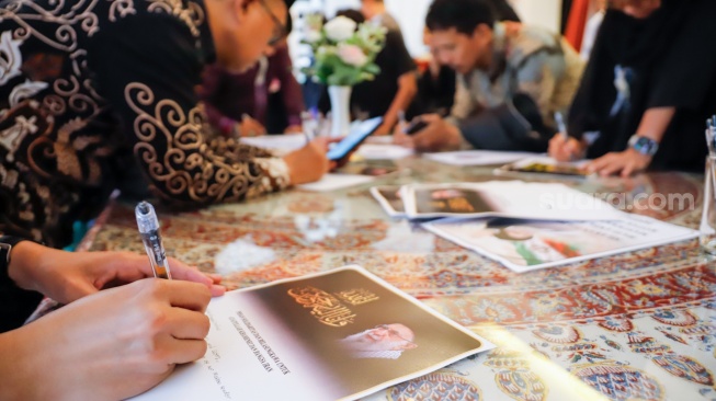 Warga menuliskan pesan dukungan saat Aksi Solidaritas dan Doa Bersama untuk Iran di Kediaman Duta Besar Iran, Jakarta, Kamis (5/3/2026). [Suara.com/Alfian Winanto]