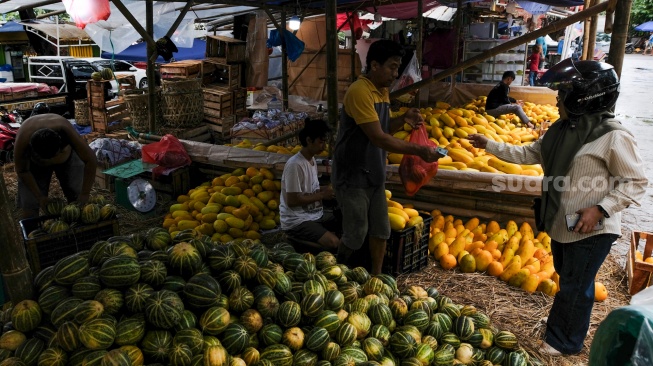 Pengunjung membeli buah timun suri atau Blewah yang dijual di Pasar Induk Kramat Jati, Jakarta, Jumat (6/2/2026). [Suara.com/Alfian Winanto]