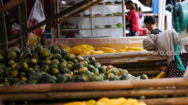 Pedagang menata buah timun suri dan Blewah yang dijual di Pasar Induk Kramat Jati, Jakarta, Jumat (6/2/2026). [Suara.com/Alfian Winanto]