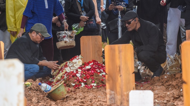 Selebriti Deddy Corbuzier (kanan) berdoa di pusara mendiang penyanyi Oxavia Aldiano atau Vidi Aldiano saat pemakaman di TPU Tanah Kusir, Jakarta, Minggu (8/3/2026). [ANTARA FOTO/Indrianto Eko Suwarso/foc]