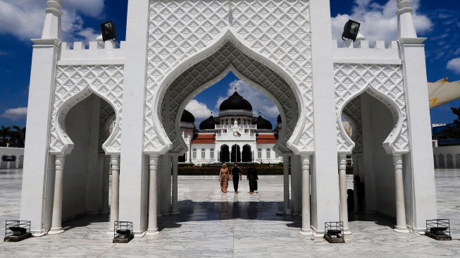 Sejumlah warga melintas di halaman Masjid Raya Baiturrahman, Banda Aceh, Aceh, Senin (9/3/2026). [ANTARA FOTO/Akramul Muslim/hma/tom]
