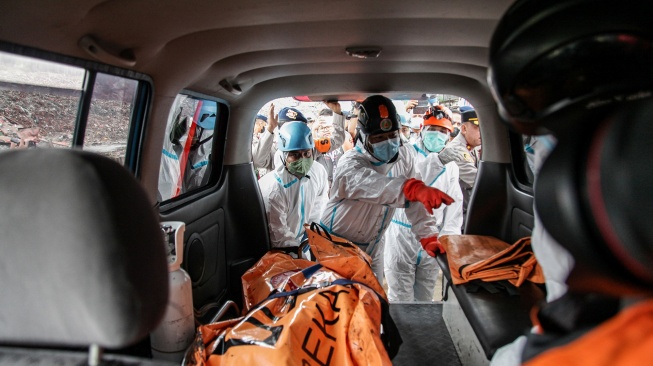Petugas memasukkan kantung berisi jenazah korban longsor gunungan sampah ke dalam mobil ambulans di Tempat Pengolahan Sampah Terpadu (TPST) Bantargebang, Bekasi, Jawa Barat, Senin (9/3/2026). [ANTARA FOTO/Darryl Ramadhan/wsj]