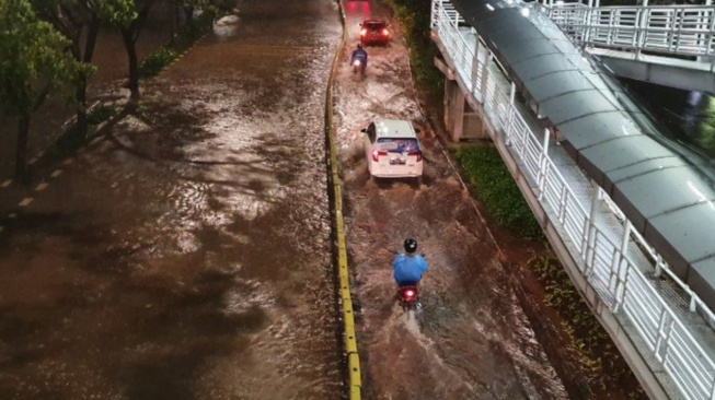 Ilustrasi jalur Transjakarta terendam banjir. Pengendara melintas di dekat Halte Bus TransJakarta Cempaka Putih yang terendam banjir setinggi 40-50 sentimeter, Selasa (25//2/2020). (Ist/ dok. PMJ)