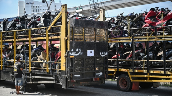 Pekerja bersiap menurunkan sepeda motor milik peserta Mudik Motor Gratis (Motis) 2026 yang dikirim dari posko pengumpan di Stasiun Jakarta Gudang, Jakarta, Kamis (12/3/2026). [ANTARA FOTO/Fauzan/wsj]