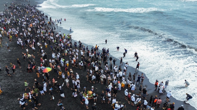 Foto udara sejumlah umat Hindu melakukan prosesi Upacara Melasti di Pantai Watu Pecak, Lumajang, Jawa Timur, Minggu (15/3/2026). [ANTARA FOTO/Irfan Sumanjaya/wsj]
