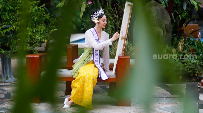 Finalis Puteri Indonesia 2026 perwakilan Provinsi Bali, Victoria Veronica Titisari Kosasieputri atau yang dikenal dengan Vicki menampilkan kemampuan melukisnya saat ditemui di Jakarta, Senin (16/3/2026).  [Suara.com/Alfian Winanto]
