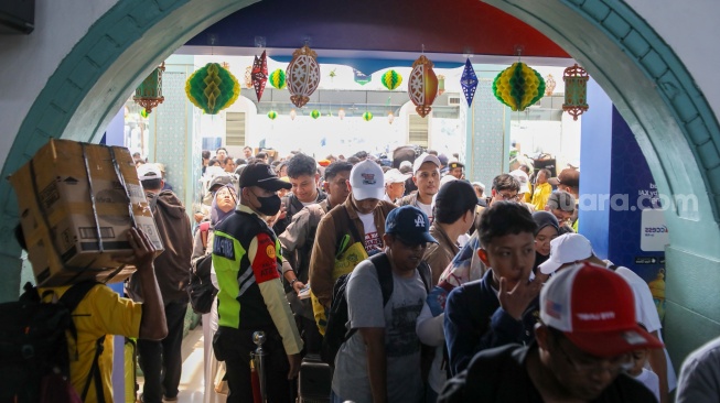 Penumpang Kereta api antre memasuki peron di Stasiun Pasar Senen, Jakarta, Selasa (17/3/2026). [Suara.com/Alfian Winanto]