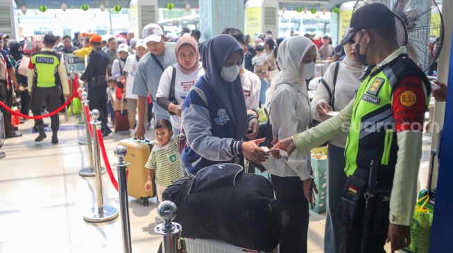 Penumpang Kereta api antre memasuki peron di Stasiun Pasar Senen, Jakarta, Selasa (17/3/2026). [Suara.com/Alfian Winanto]