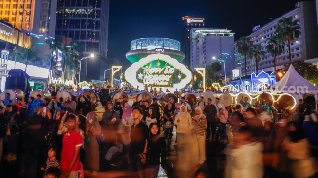 Sejumlah warga menyaksikan pawai obor dan fetival bedug dalam rangka menyambut Hari Raya Idul Fitri 1447 Hijriah di Bundaran HI, Jakarta, Jumat (20/3/2026). [Suara.com/Alfian Winanto]
 