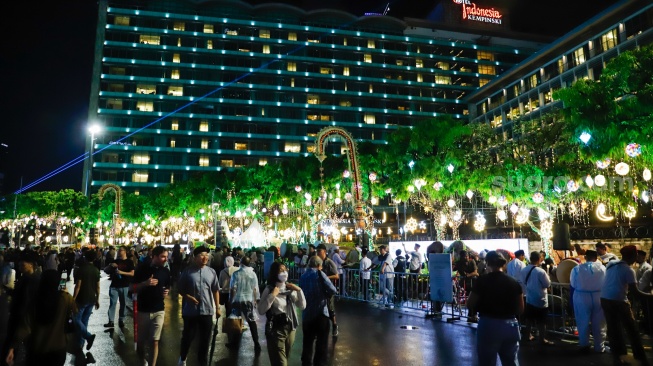 Sejumlah warga menyaksikan pawai obor dan fetival bedug dalam rangka menyambut Hari Raya Idul Fitri 1447 Hijriah di Bundaran HI, Jakarta, Jumat (20/3/2026). [Suara.com/Alfian Winanto]
 